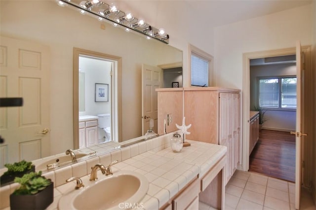 bathroom featuring tile patterned flooring, vanity, and toilet