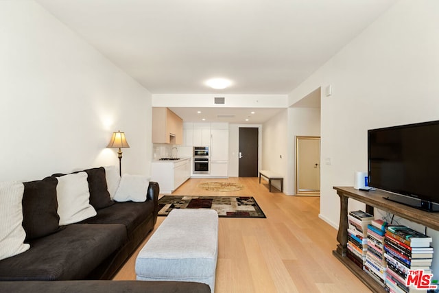 living room with sink and light hardwood / wood-style floors