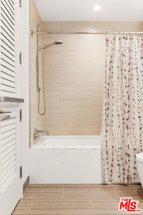 bathroom with toilet and shower / bathtub combination with curtain