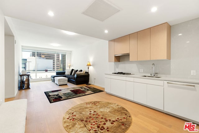 kitchen featuring dishwasher, sink, light brown cabinets, gas cooktop, and light hardwood / wood-style flooring