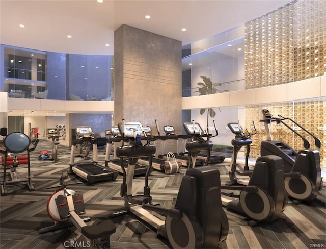 exercise room with a high ceiling and carpet flooring