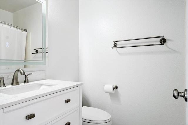 bathroom featuring toilet and vanity