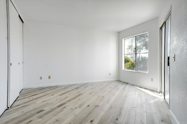 unfurnished bedroom featuring light wood-style flooring and baseboards