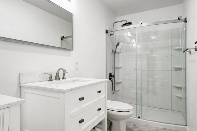 full bath featuring toilet, a shower stall, and vanity