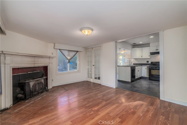 unfurnished living room featuring sink, dark hardwood / wood-style flooring, and a fireplace