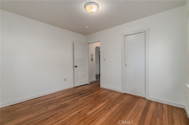 unfurnished bedroom featuring hardwood / wood-style flooring and a closet