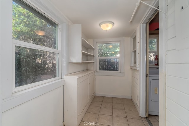 washroom featuring washer / dryer, light tile patterned flooring, and plenty of natural light