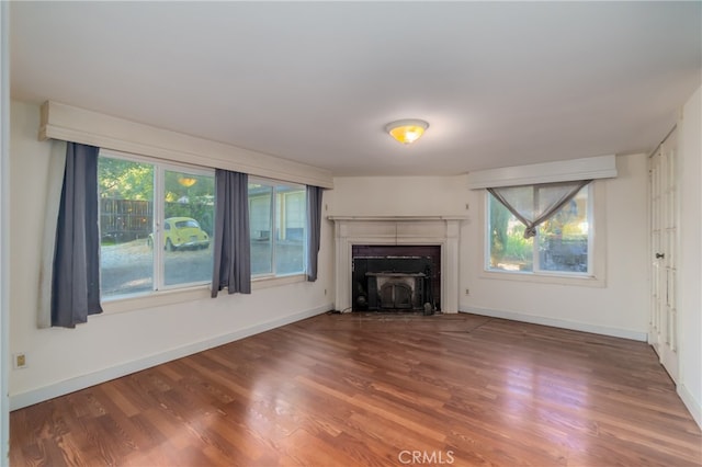 unfurnished living room with wood-type flooring and plenty of natural light