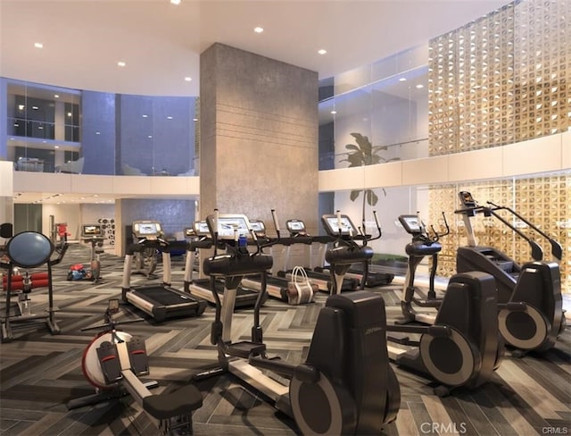 gym with a towering ceiling and carpet flooring