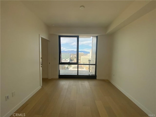 unfurnished room with light wood-type flooring