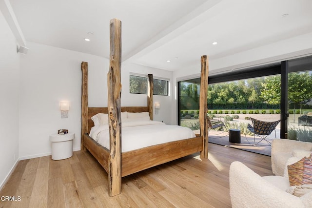 bedroom featuring beam ceiling, access to exterior, and light wood-type flooring