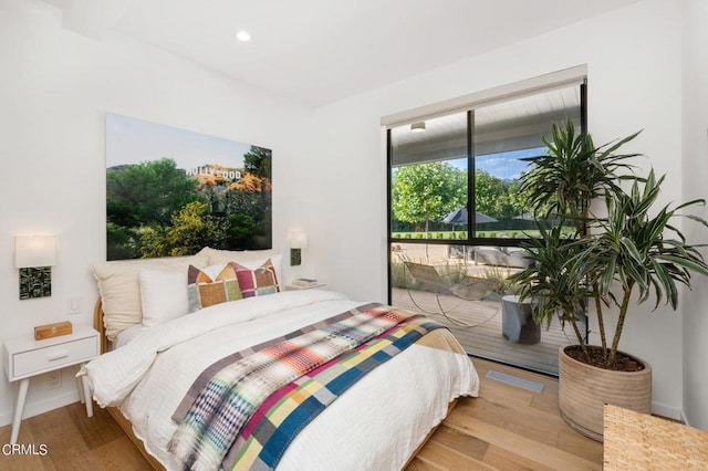 bedroom featuring access to exterior and light wood-type flooring