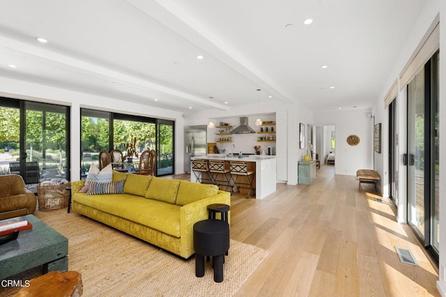 living room featuring beam ceiling and light wood-type flooring