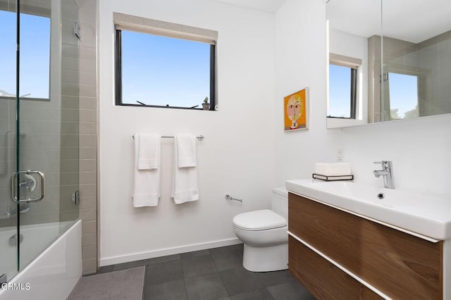 full bathroom featuring vanity, toilet, bath / shower combo with glass door, and a wealth of natural light