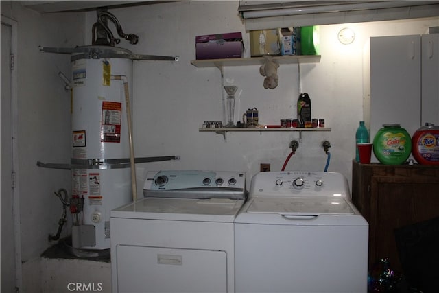 clothes washing area featuring water heater and independent washer and dryer