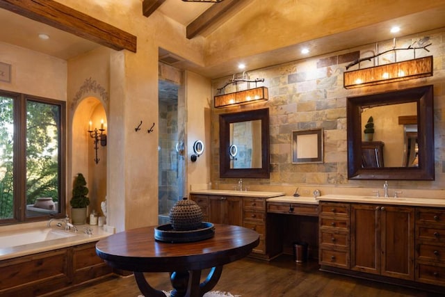 bathroom featuring lofted ceiling with beams, wood-type flooring, a washtub, and vanity