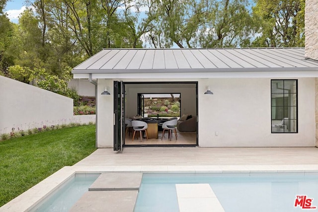 view of pool featuring an outbuilding, a patio area, and a lawn