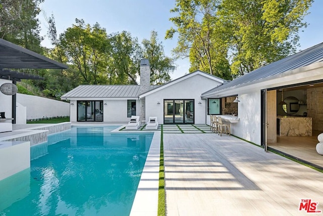 view of swimming pool featuring a bar and a patio