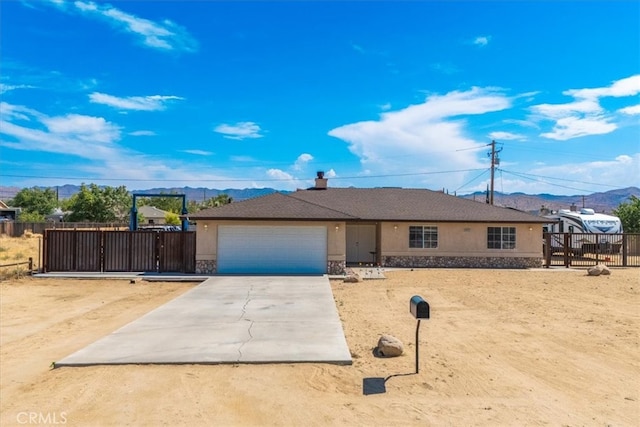 ranch-style home with a garage and a mountain view