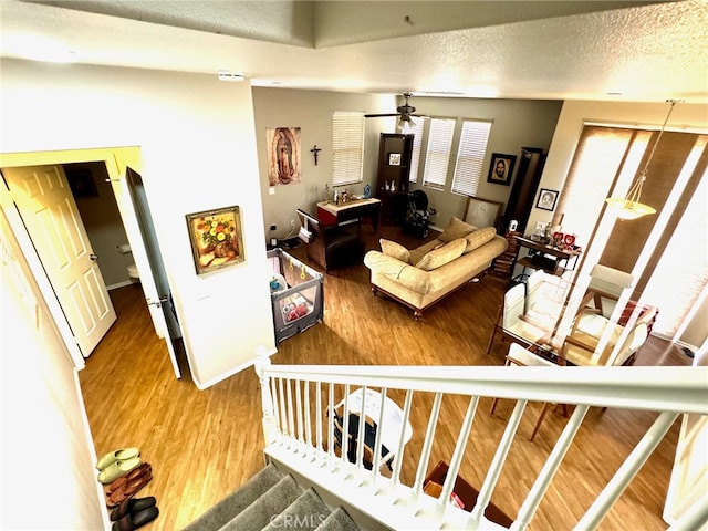 living room featuring a textured ceiling, hardwood / wood-style floors, and ceiling fan