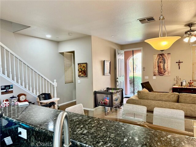 living room featuring ceiling fan and a textured ceiling