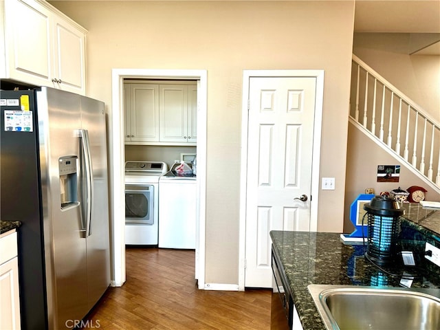 kitchen featuring dark stone countertops, white cabinetry, independent washer and dryer, dark hardwood / wood-style flooring, and stainless steel fridge with ice dispenser