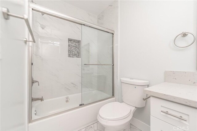 full bathroom featuring enclosed tub / shower combo, vanity, tile patterned flooring, and toilet