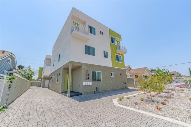 rear view of property with a balcony and a patio area