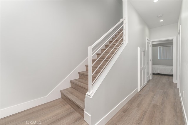 staircase with hardwood / wood-style flooring