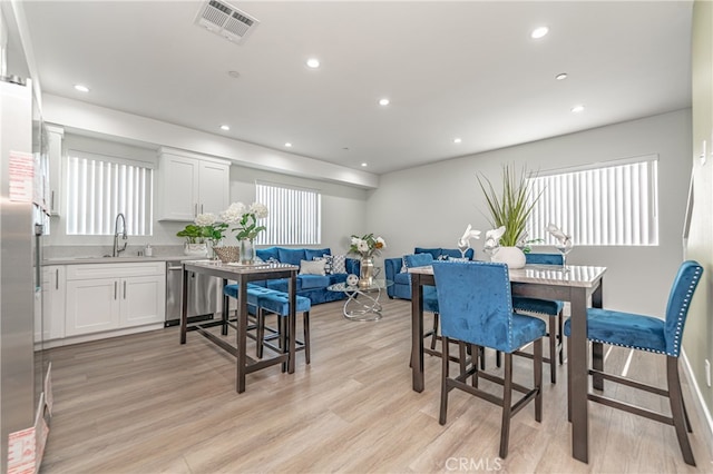 dining area featuring light wood-type flooring and sink