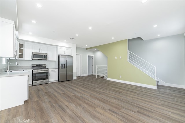 kitchen featuring appliances with stainless steel finishes, white cabinetry, sink, and dark wood-type flooring