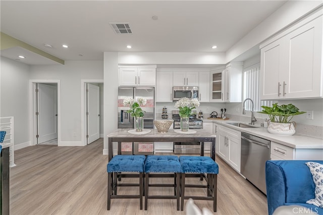 kitchen featuring white cabinetry, light hardwood / wood-style floors, appliances with stainless steel finishes, and sink