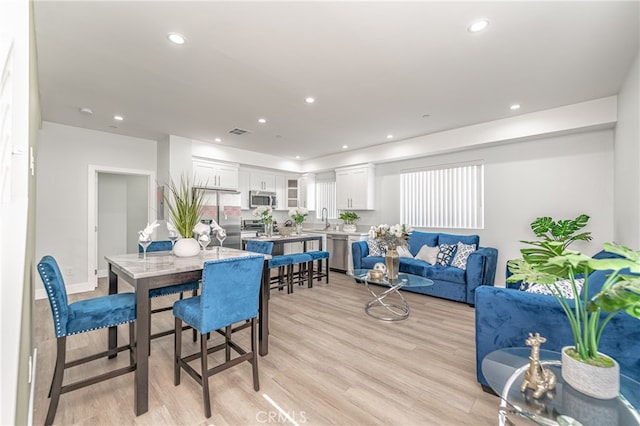 dining room with sink and light hardwood / wood-style flooring