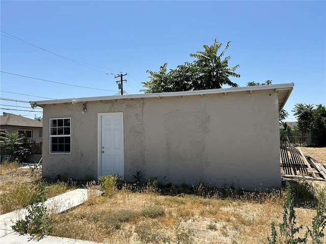 back of property featuring an outbuilding