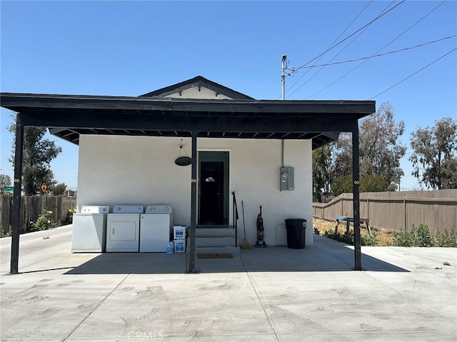 view of front of home with washer / dryer and a patio