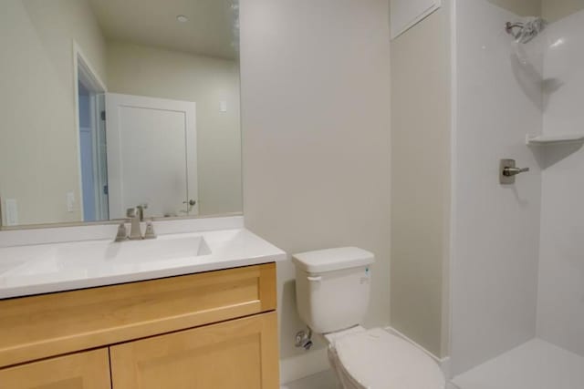 bathroom featuring vanity, toilet, and a shower