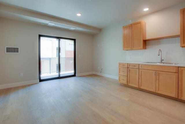 kitchen with sink, light brown cabinets, and light wood-type flooring