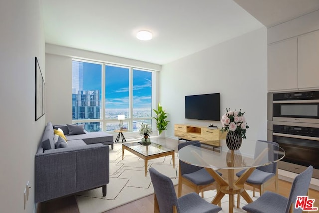 living room featuring expansive windows and light hardwood / wood-style floors