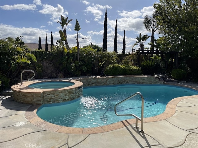 view of swimming pool with an in ground hot tub