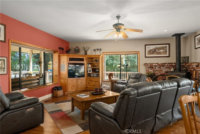 living room with light hardwood / wood-style floors, a healthy amount of sunlight, and ceiling fan