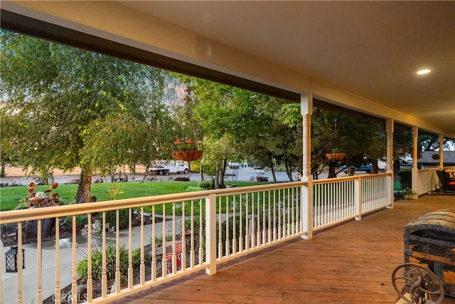 wooden deck with a lawn and a water view