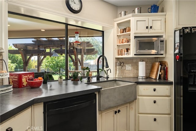 kitchen with a wealth of natural light, sink, black appliances, and backsplash