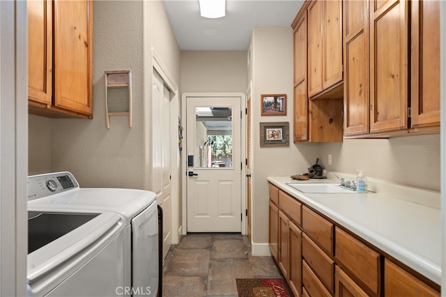 washroom with sink, washing machine and dryer, and cabinets