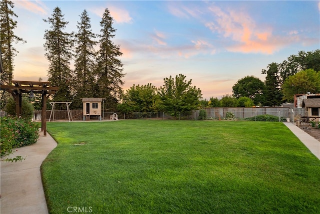 yard at dusk featuring an outdoor structure