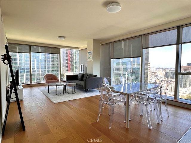 dining area featuring plenty of natural light, hardwood / wood-style floors, and expansive windows