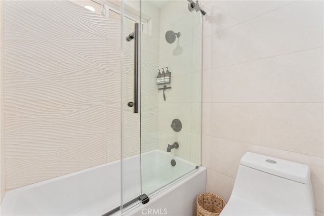 bathroom featuring shower / bath combination with glass door and toilet