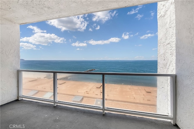 balcony with a water view and a beach view