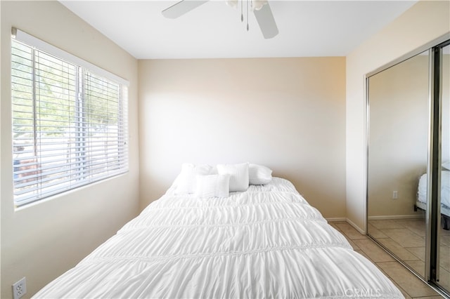 bedroom with light tile patterned floors, a closet, and ceiling fan