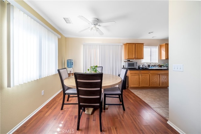 dining area featuring dark hardwood / wood-style floors, sink, and ceiling fan