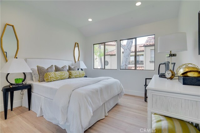 bedroom with light hardwood / wood-style floors and vaulted ceiling